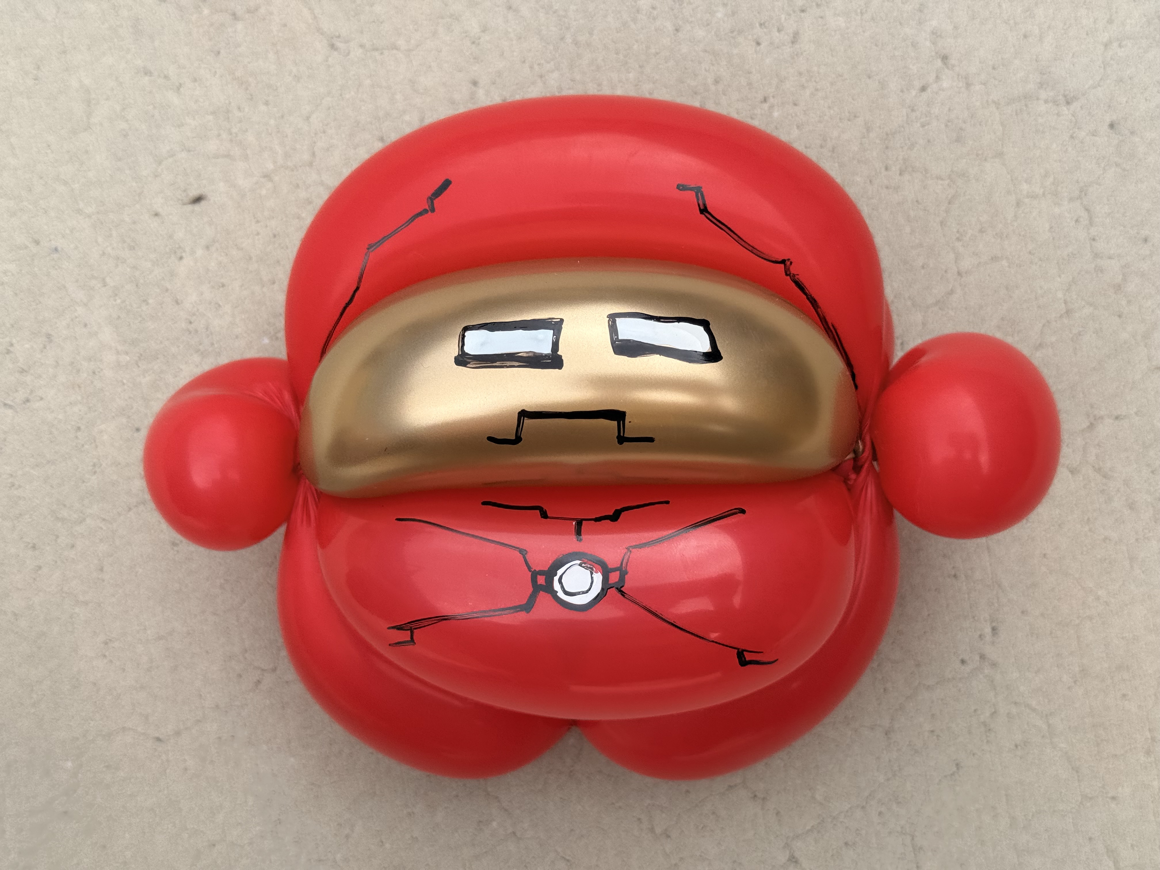 Iron Man helmet balloon sculpture with glowing arc reactor