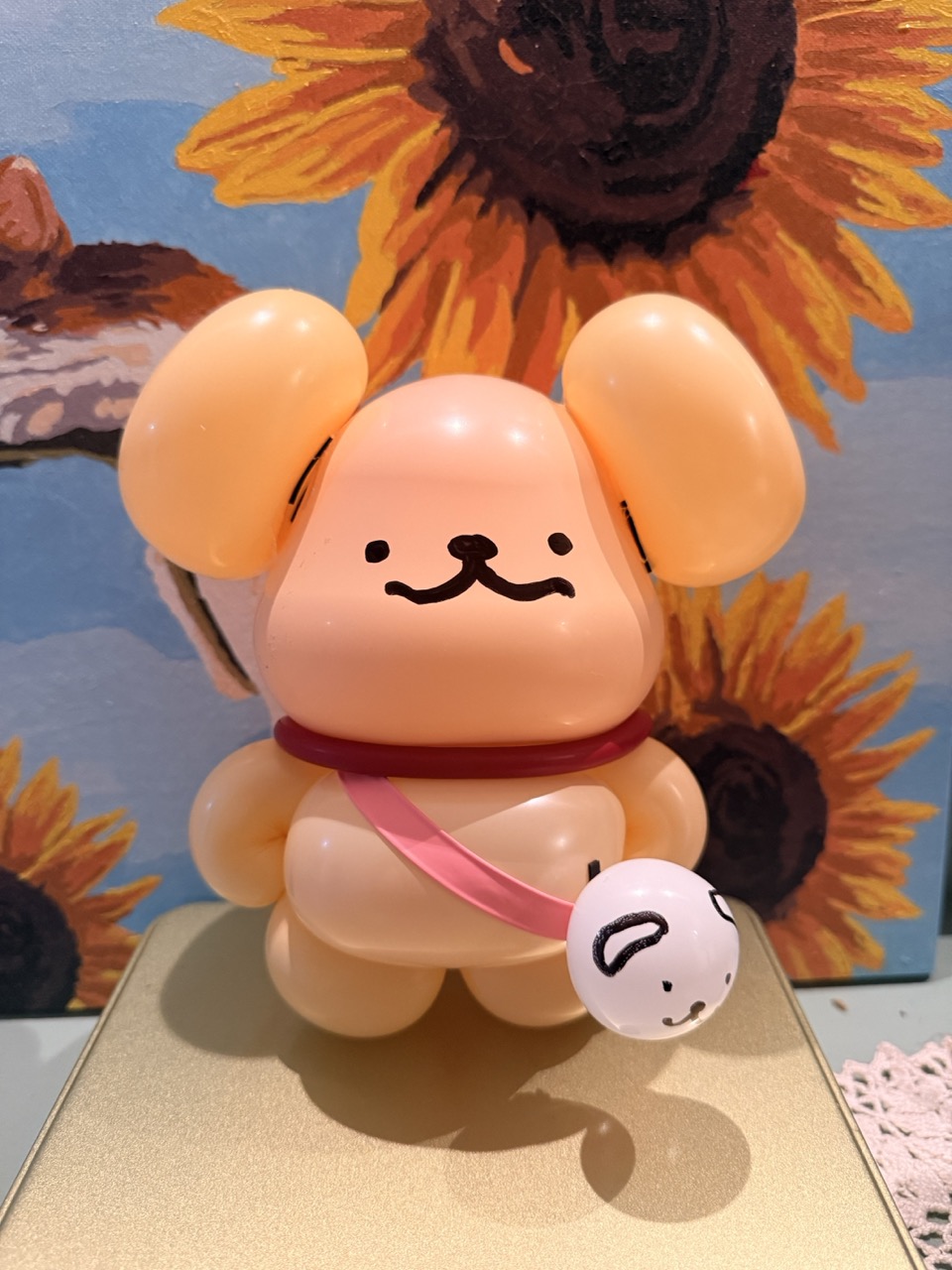 Pompompurin character balloon closeup with sunflower background