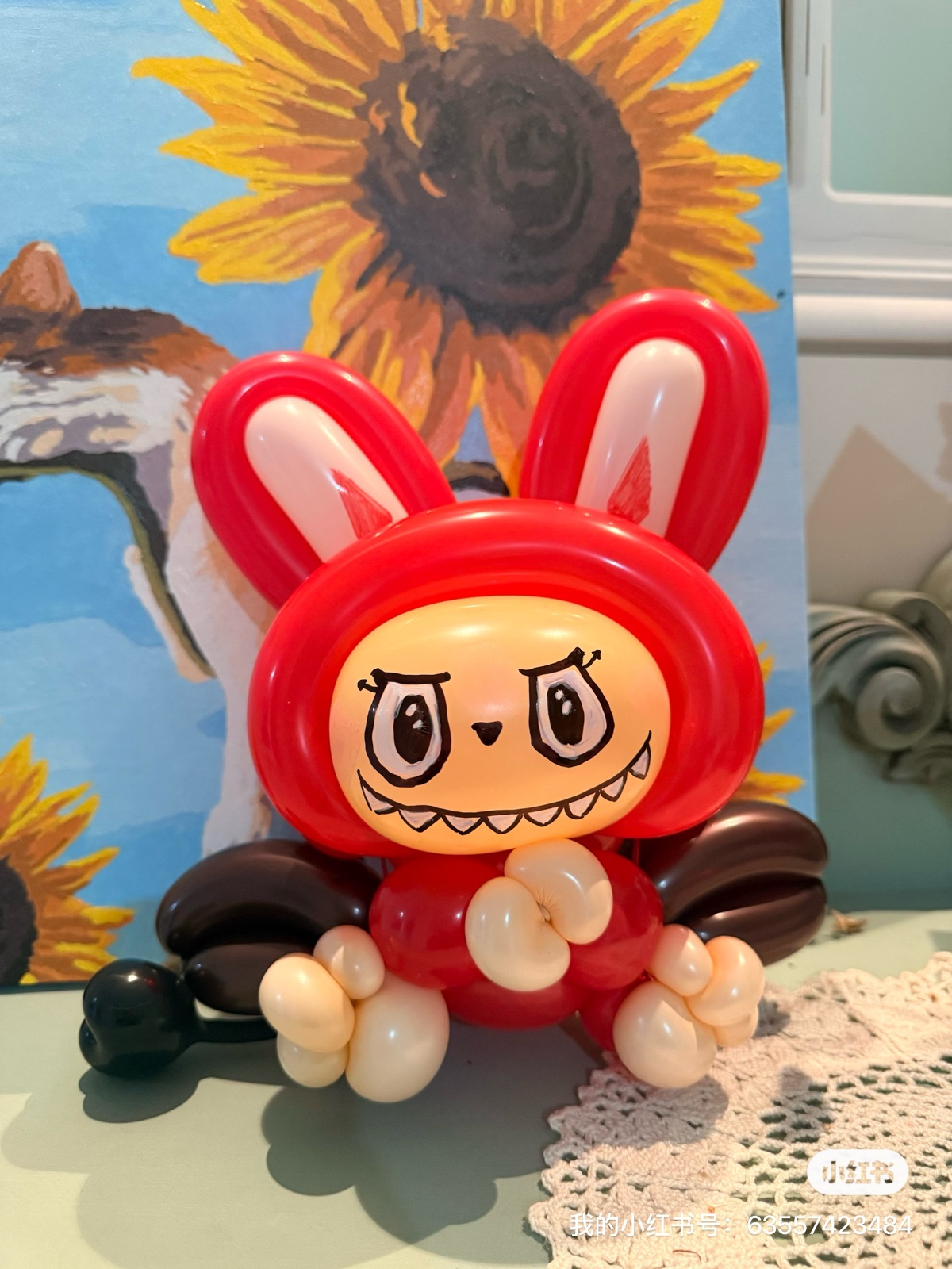 Red Labubu balloon art with sunflower painting