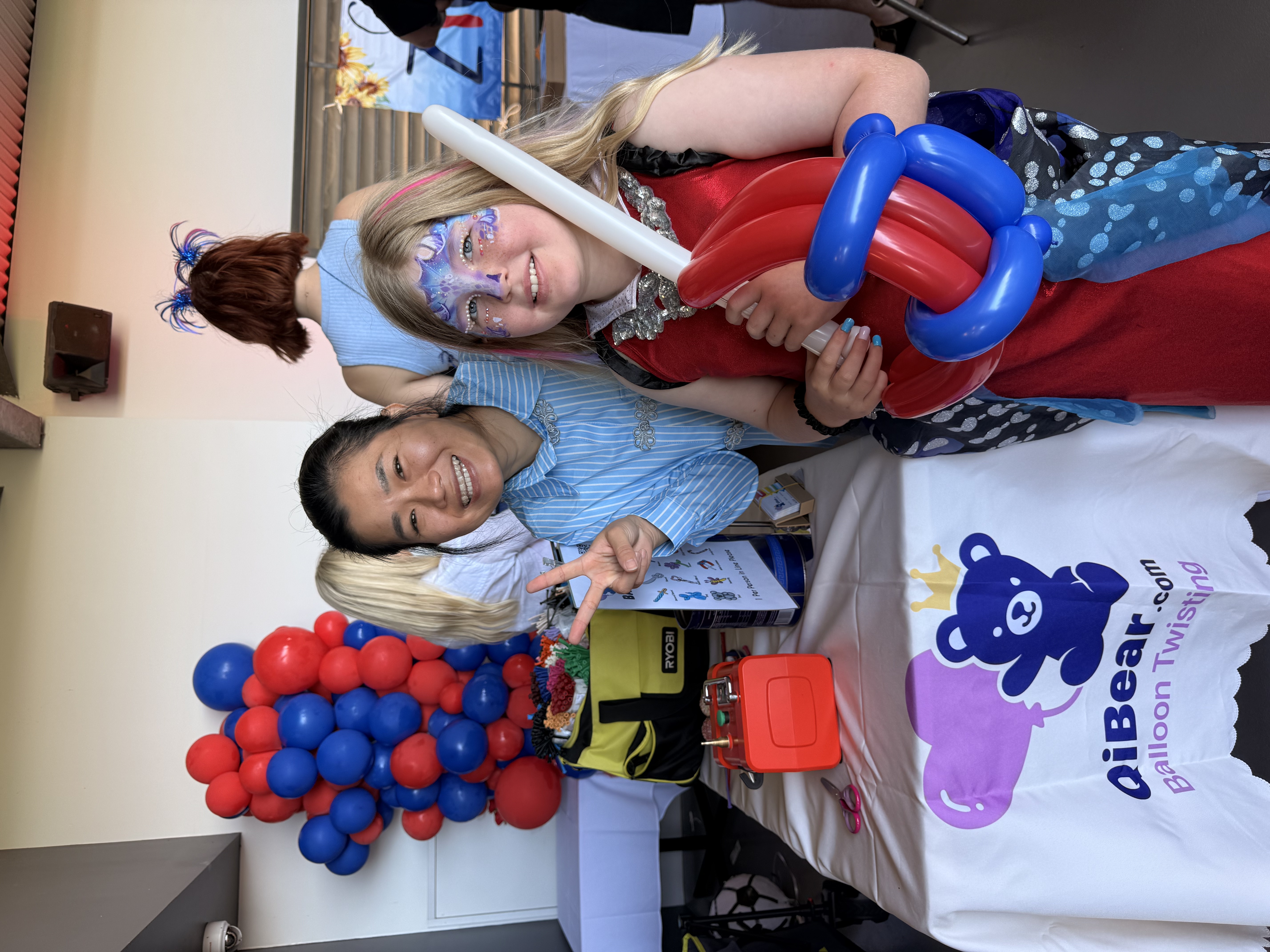 Balloon artist with girl holding Spiderman balloon