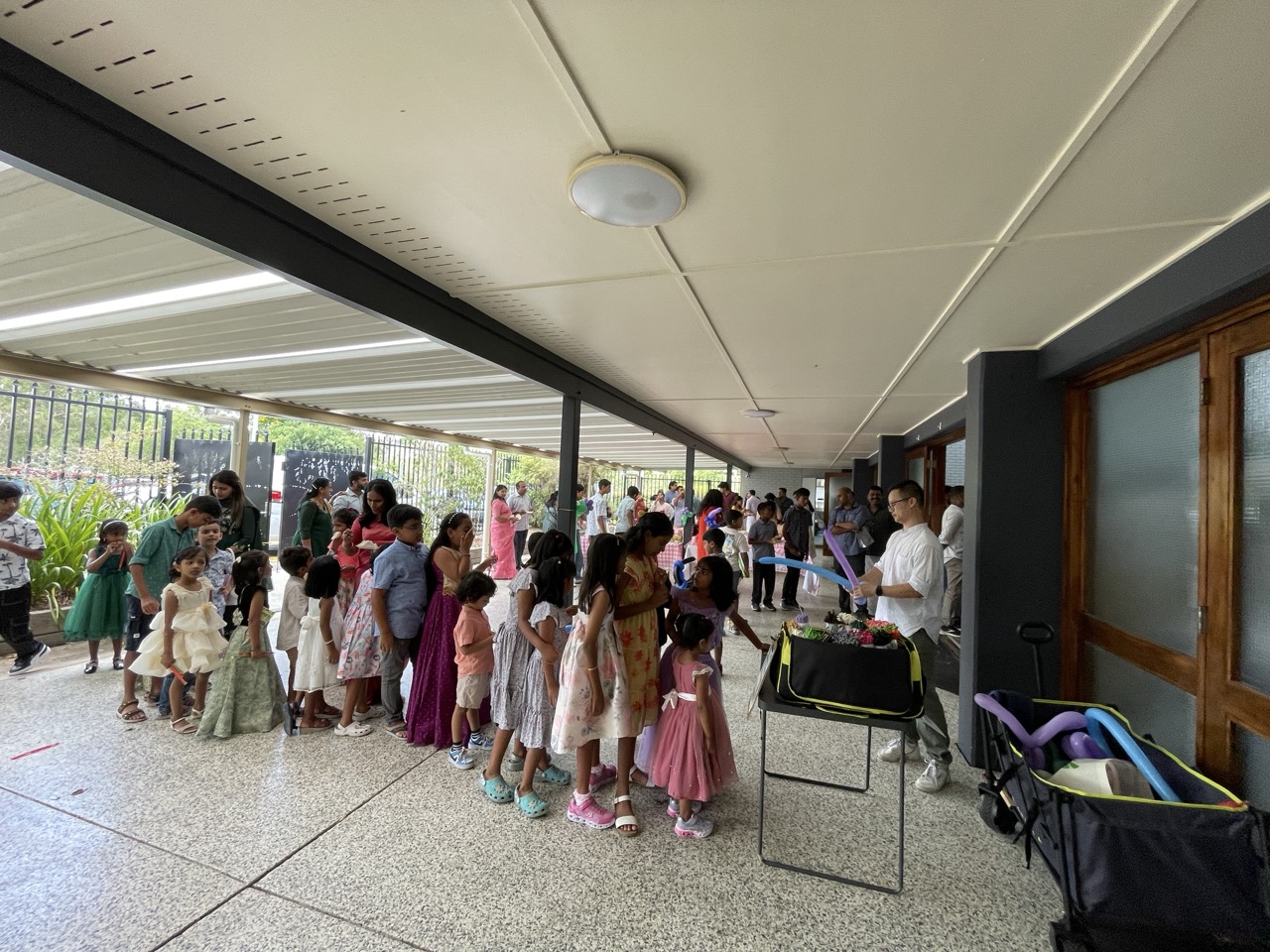 Children lining up for QiBear balloon twisting at an outdoor event